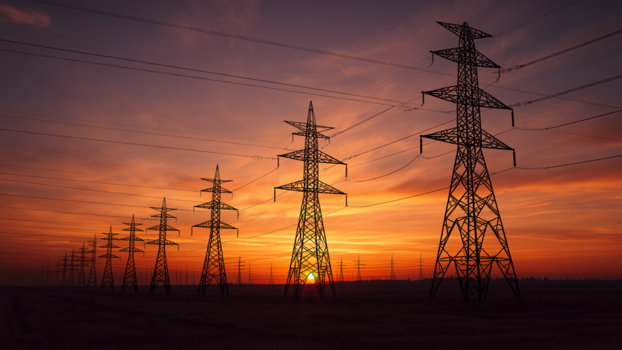 High-voltage electricity transmission towers at sunset